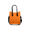 An orange tote bag with black handles and polka dot holes, featuring a removable shoulder strap.
