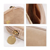 A stylish mini makeup bag in beige suede with a gold zip and tag, featuring a smooth interior and soft texture.