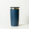 A drink bottle in navy blue with a stainless steel rim and a black lid. It features a logo on the surface.