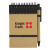 A brown recycled jotter pad with a black pen and elastic band, featuring a logo on the cover.