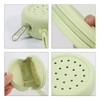 A round, pale green silicone pouch with a zipper and perforated holes, featuring a silver clip and textured interior.