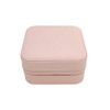 A pink PU leather jewellery box with a textured surface and a zipper closure. It has a simple, compact design.