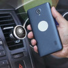 A dark blue smartphone held next to a silver magnetic phone holder attached to a car dashboard.