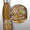 A drink bottle with a brown wood-like finish, featuring a floral design and a branding logo.