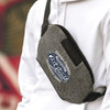A grey Urban Belt Bag with a logo, worn across a person's body over a white hoodie.