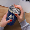 A drink bottle in navy blue with a silver lid, held by hands, features a logo on the front.