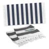 Striped cotton towels in navy blue and white, featuring fringe edges and a logo, displayed together.