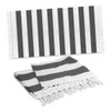 A striped black and white cotton towel with tassels, featuring a flat and folded design.