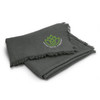 A green throw blanket with a fringed edge and a logo in the corner.