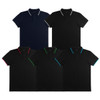 A collection of five men's polo shirts in navy, black, and various accent colours. Each shirt has a logo.
