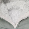 A detail of a soft, fluffy inner lining in a hoodie, featuring grey outer material and textured white fleece.