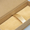 A kraft gift box with a soft interior and a gold ribbon, suitable for pen packaging.