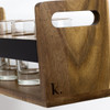 A wooden tray in a natural finish with a black band, holding several clear glass shot glasses, featuring a branding logo.