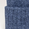 A blue knitted beanie with a folded cuff, showcasing a textured pattern. It features a branding logo.