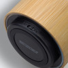 A bamboo Bluetooth speaker featuring a sleek design, with a black base and an on/off switch.