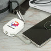 A white power bank with a logo, connected to a smartphone via a grey cable, placed on a wooden surface.