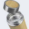 A drink bottle made of bamboo with a stainless steel lid and a mesh filtration insert visible inside.