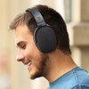 Black over-ear headphones worn by a man, featuring a sleek design and a logo on the side.