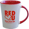 A ceramic coffee mug with a white exterior and a red interior, featuring a logo.