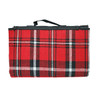 A red and black tartan picnic rug with a black handle. It features a plaid pattern.