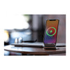 A sleek silver wireless charging stand with a smartphone, displaying a charging indicator.