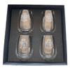 A set of four clear glass wine glasses with etched white text, presented in a black gift box.