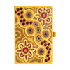 A yellow patterned journal with Aboriginal-inspired designs, featuring vibrant flowers and circular motifs, with a logo.