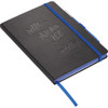 A black bound journal with a blue elastic band, featuring embossed text and a ribbon bookmark.