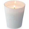 A white scented candle in a glass container, featuring a lit wick, with a soft glow.