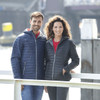 A navy and black packable puffer jacket for men and women, featuring hoods and zippers, displayed by two models.