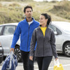 A blue and a grey women's polyfleece jacket are worn by models outdoors, with cars in the background.