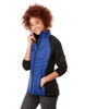 A woman smiles while wearing a blue and black insulated jacket, featuring a zip front and pockets.
