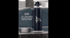 A drink bottle in dark blue with a flip straw lid, featuring a silver logo and standing on a white base.