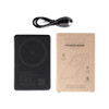 A slim black power bank with a wireless charging surface, accompanied by a charging cable and packaging.