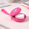 A pink silicone pouch with holes strap, unzipped to reveal white contents inside, on a light surface.
