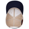 A beige and navy 6 panel mid-profile baseball cap with an internal structure displayed from above.
