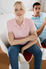 A woman in a pink polo shirt and a man in a light blue polo shirt are seated in modern chairs.