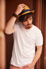 A white t-shirt worn by a man, complemented by a straw hat, with a neutral background.