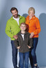 A family wears lightweight polar fleece jackets in green, orange, and dark grey, featuring pockets and zip details.