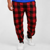 Comfy flannel jogger pants in red and black check pattern, featuring elastic cuffs and pockets. Logo visible on waistband.