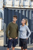 A grey long-sleeve women's work T-shirt is paired with a green long-sleeve men's T-shirt against a shipping container backdrop.