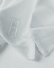 A white polo shirt featuring a logo, displayed with a focus on the fabric and collar details.