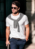 A white men's T-shirt with a grey sweater casually draped around the shoulders, paired with dark trousers and sunglasses.