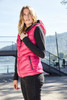A pink ladies down vest with a hood, featuring zip pockets, displayed outdoors near a lake.