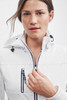 A white Ladies Maritime Jacket with a hood, featuring zippered pockets and a logo.