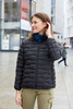 A black padded jacket worn by a woman outdoors, featuring a zip closure and a logo on the chest.