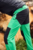 Men's trekking pants in vibrant green and black, featuring cargo pockets and a sporty design. Includes branding.