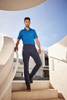 Cargo pants in navy blue worn by a man standing on a staircase, paired with a blue polo shirt.