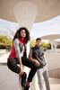 A ladies' fleece vest in red, paired with a grey vest, worn by models in a modern architectural setting.