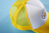 A yellow and white 5 panel polyester mesh trucker cap featuring a round patch and mesh sides.
